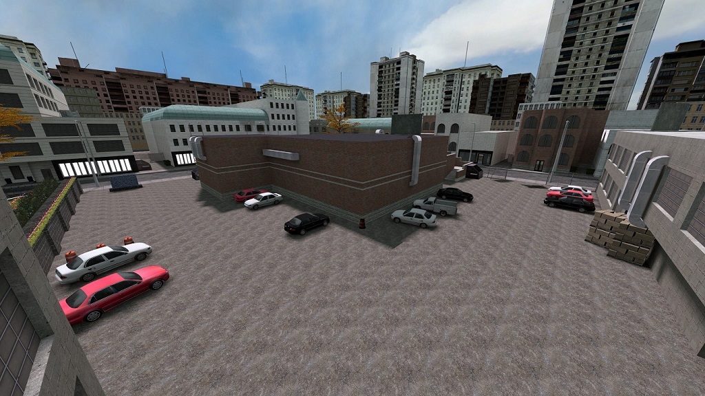 A L-shaped car park behind a branch bank with large city buildings in the background.